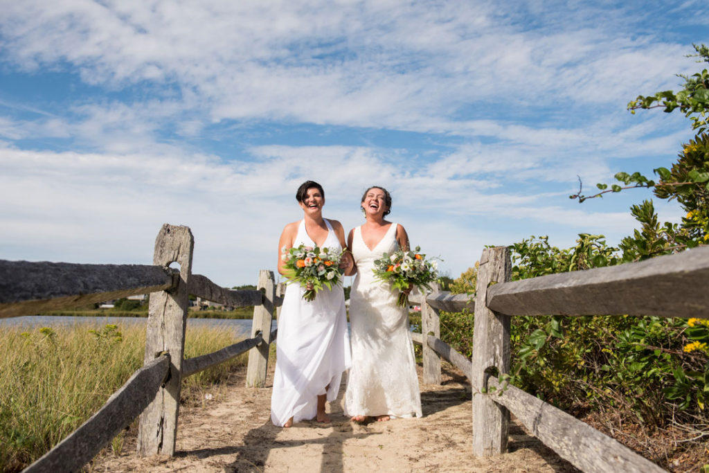 two brides walking and laughing on the beach cape cod massachusetts