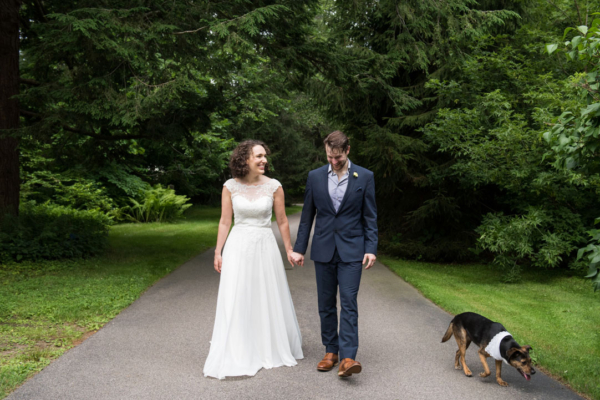 couple walking with their dog after backyard wedding