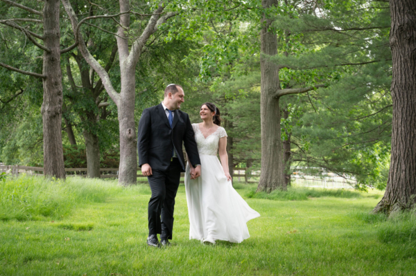 bride and groom walking-in-the-woods at gore place wedding